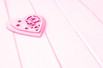 Pink heart on a white wood background.