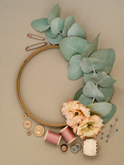 Flowers and leaves near embroidery supplies.