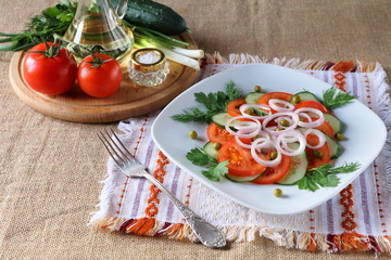 Fresh tomato salad with greens and cucumbers.