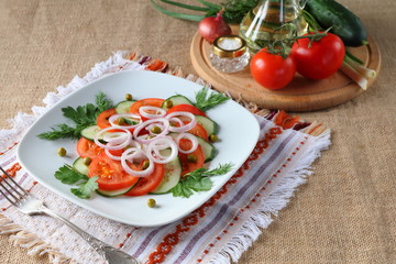 Fresh tomato salad with greens and cucumbers.