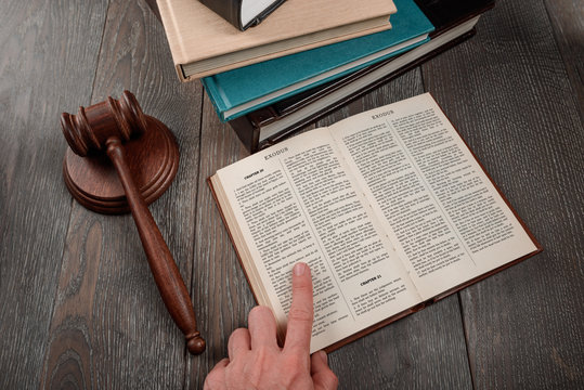 Judge reading book of Exodus