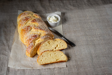Sliced challah jewish bread served with cottage cheese on linen cloth