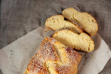 Fresh sliced challah jewish bread on paper over linen cloth