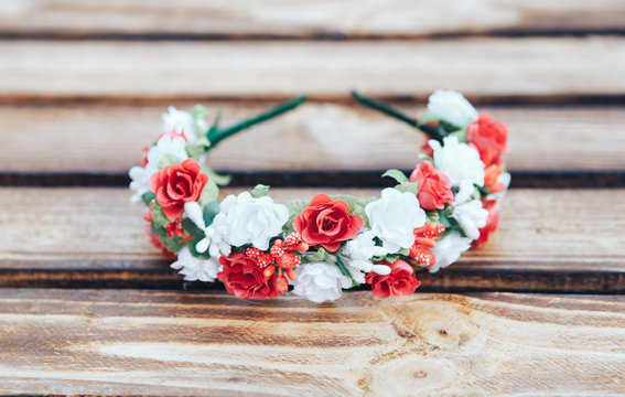 Handmade hoop red and white flowers. Red and white hair band on wooden background