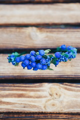 Handmade hoop blue flowers. Blue hair band on wooden background. Top view
