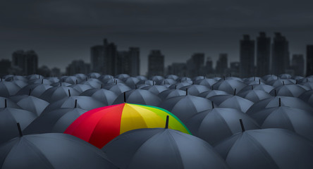 businessman with colorful rainbow umbrella among others, unique different concept