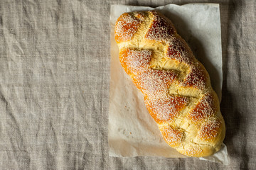 Baker holding baking tray with fresh baked challah jewish bread