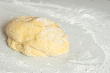 Dough for traditional bread cooking on light wooden background, copy text. Top view, flat.