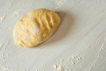 Dough for traditional bread cooking on light wooden background, copy text. Top view, flat.