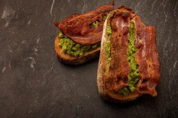 Avocado with bacon on rustic style bread with copy space 
