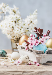 Easter eggs and spring flowers on rustic wooden background.Easter holiday card copy space.