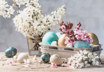 Easter eggs and spring flowers on rustic wooden background.Easter holiday card copy space.