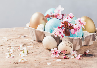 Easter eggs and spring flowers on rustic wooden background.Easter holiday card copy space.
