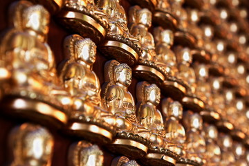 Rows of golden Buddha Statues on the wall, Golden Buddha Chinese style pattern row for background
