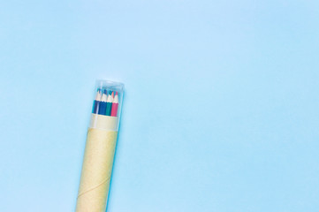 Color pencils in pencil case on blue background top view flat lay with copy space. Wooden colored...