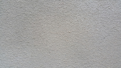The texture of the plastered surface of the wall is gray as a background