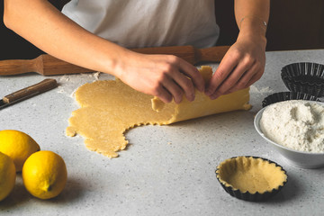 a process of making tartlets, female hands working with pastry dough