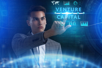 The concept of business, technology, the Internet and the network. A young entrepreneur working on a virtual screen of the future and sees the inscription: Venture capital