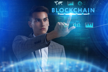 The concept of business, technology, the Internet and the network. A young entrepreneur working on a virtual screen of the future and sees the inscription: blockchain