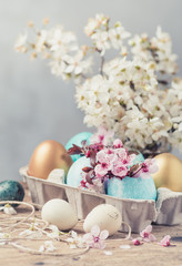 Easter eggs and spring flowers on rustic wooden background.Easter holiday card copy space.