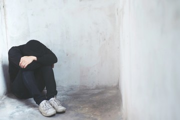 Young man emotion strain sorry sad. depressed man Absent minded Sit down bend down the head on the floor. dramatic concept  © methaphum