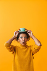 Cheerful african woman wearing sweater holding cup