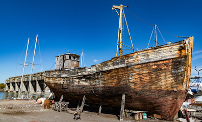 Old wooden fishing boat in a repair yard beside the World War 2 BETASOM submarine base in Bordeaux,...