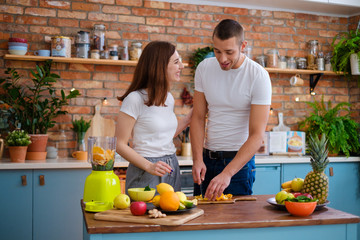 Young couple making smoothie in kitchen