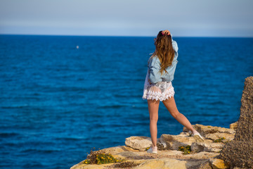 Full рушпре  portrait of young girl stand on rocks close to sea 