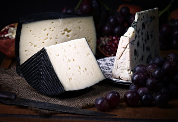 Spanish sheep cheese and Roquefort cheese with grape and other fruit bodegon with classic light on wood