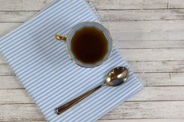Fresh fragrant tea in blue Cup on wooden background.