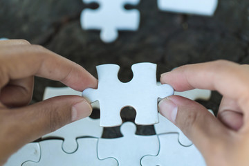 Jigsaw puzzle in the hand of a businessman,  Business team assembling Jigsaw puzzle.