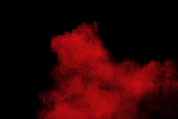 Fototapeta na wymiar Red color powder explosion on black background.Freeze motion of red dust particles splashing.