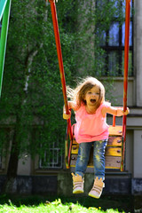 summer activity. Small kid playing in summer. Happy laughing child girl on swing. childhood daydream .teen freedom. romantic little girl on the swing, sweet dreams. Playground in park