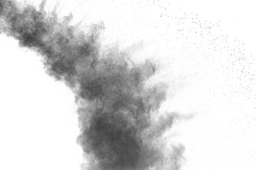 Black powder explosion against white background. Black dust particles splashing.