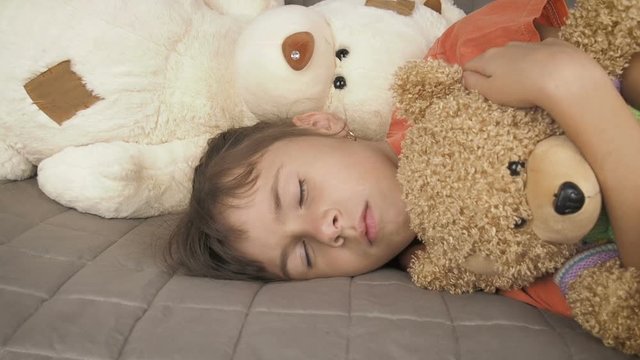 Teen girl sleeping with a teddy bear. The girl sleeps in toys.