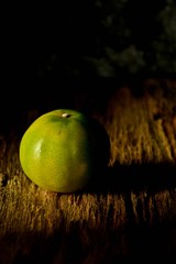 green orange on old chopping board with shadow in the kitchen room at morning