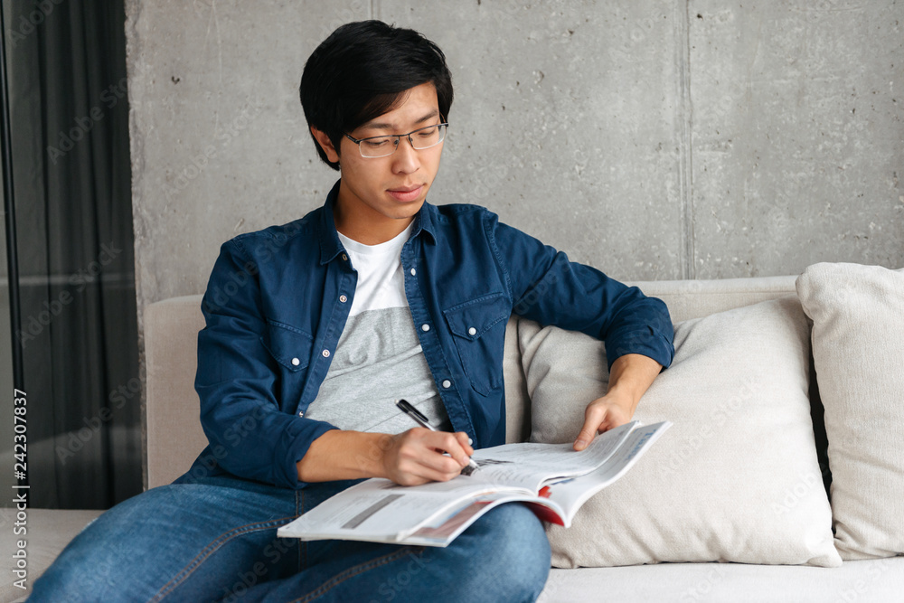 Canvas Prints Confident asian man sitting on a couch