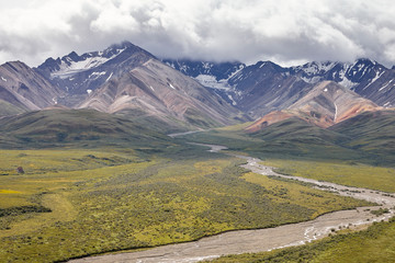 Dry River Bed Running Through Valley Between Mountains In Alaska