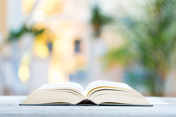 Large open hardcover book on a bright interior room background
