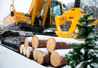 Hydraulic manipulator. Yellow log loader. Forestry equipment for moving wood and other materials. Heavy diesel tractor, industrial machinery. Winter time