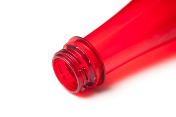 closeup of open red plastic bottle neck on white background