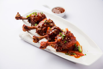 Szechuan Chicken which is a popular Indo-Chinese non vegetarian recipe. served in a plate with chilli sauce. selective focus