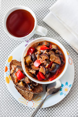 Vegetable stew with eggplant, red pepper and tomatoes on toasted rye bread