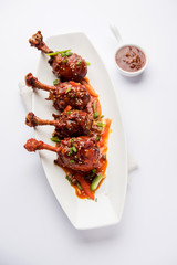 Szechuan Chicken which is a popular Indo-Chinese non vegetarian recipe. served in a plate with chilli sauce. selective focus