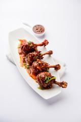 Szechuan Chicken which is a popular Indo-Chinese non vegetarian recipe. served in a plate with chilli sauce. selective focus