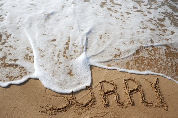 The word sorry writing on sand beach with waves ocean.
