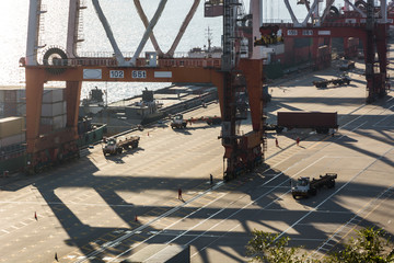 Industrial port crane lift up loading export containers box onboard from truck at port of...