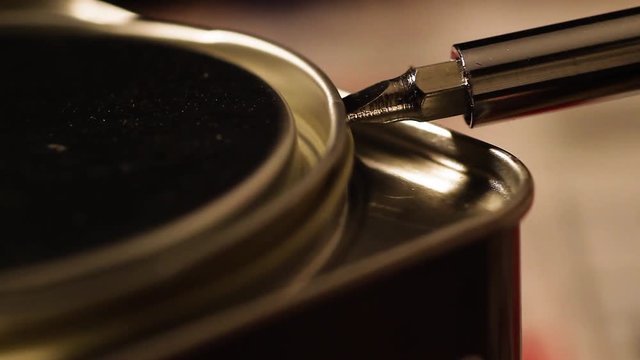 Someone open a jar of varnish with a screwdriver. Close up shots of a small wood working project.