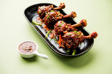 Szechuan Chicken which is a popular Indo-Chinese non vegetarian recipe. served in a plate with chilli sauce. selective focus